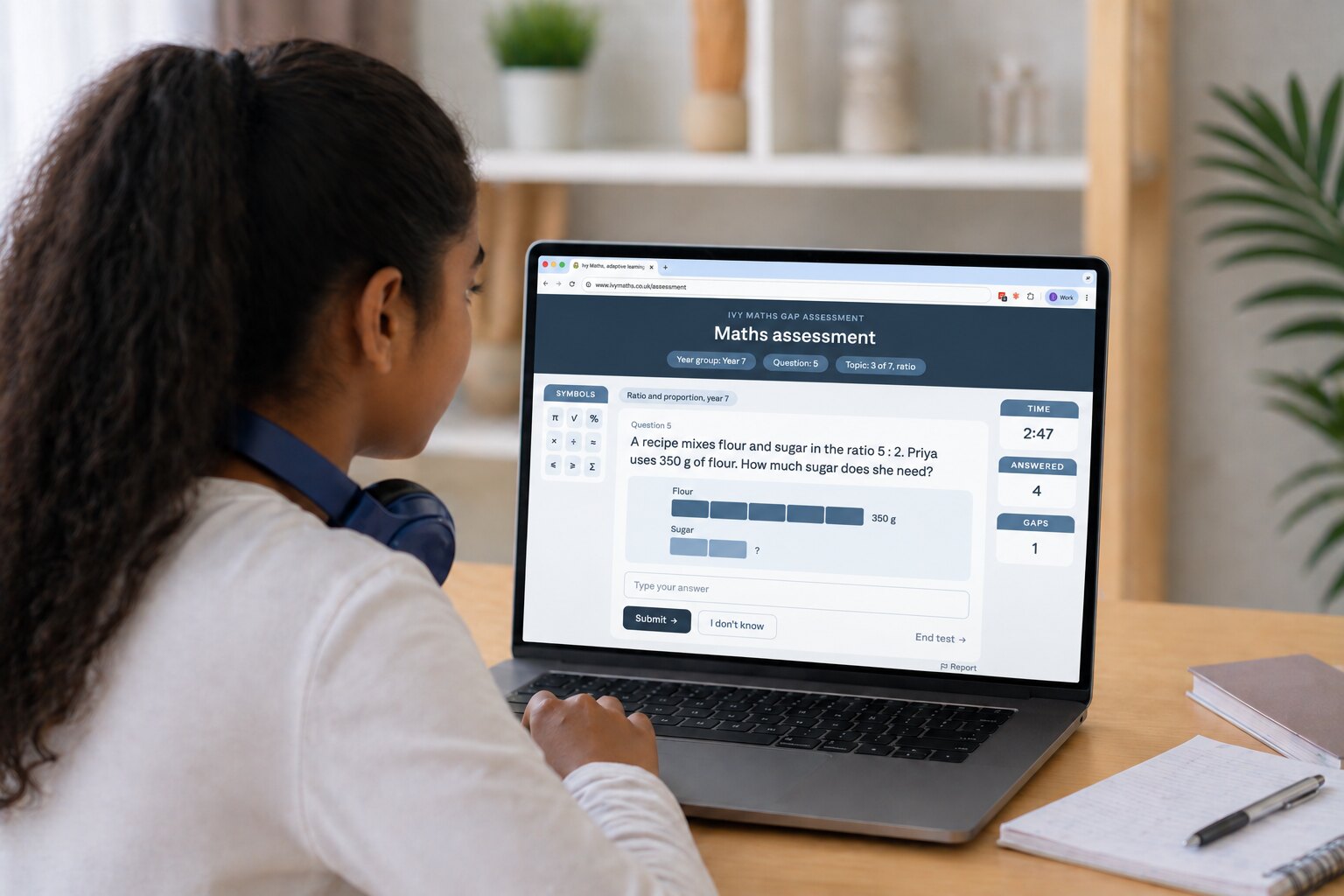 A student at a laptop at home, answering a question in the maths assessment